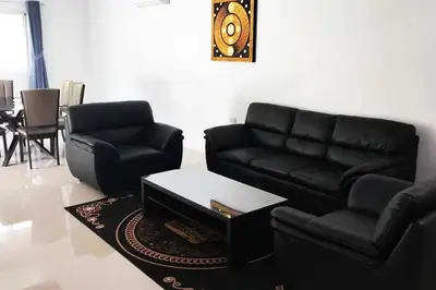 a living room with a black couch and a table at 3 Bedrooms Pool Villa in Kamala in Kamala Beach