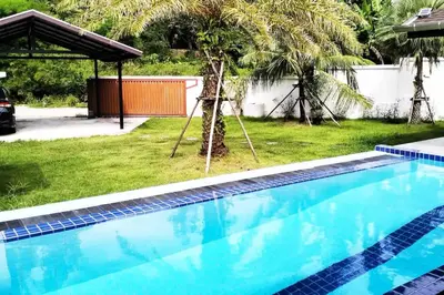 a swimming pool in a yard with a palm tree at 3 Bedrooms Pool Villa in Kamala in Kamala Beach