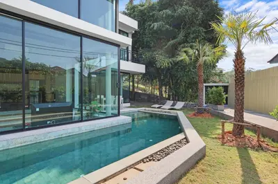a house with a swimming pool in the yard at Canary Villa - Kamala Beach in Kamala Beach
