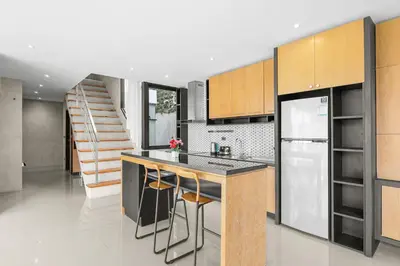 a kitchen with a counter and a refrigerator and a staircase at Canary Villa - Kamala Beach in Kamala Beach