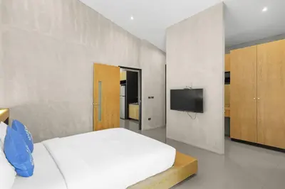 a bedroom with a white bed and a tv at Canary Villa - Kamala Beach in Kamala Beach