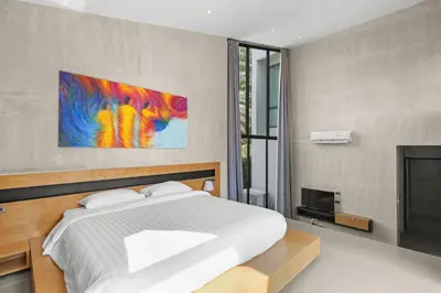 a bedroom with a bed and a painting on the wall at Canary Villa - Kamala Beach in Kamala Beach