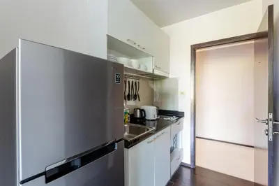 a kitchen with a stainless steel refrigerator and a sink at Cozy apartment at The Title Rawai by Lofty in Rawai Beach