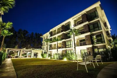 a large building with palm trees in front of it at Cozy apartment at The Title Rawai by Lofty in Rawai Beach