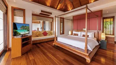 a bedroom with a four poster bed and a television at Seaview Villa Yang Som at Surin Beach in Thalang