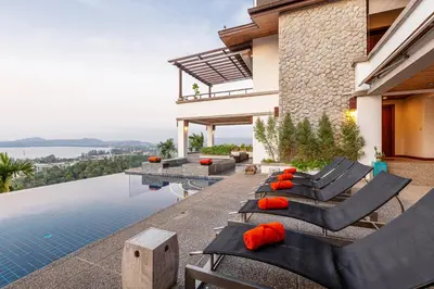 a house with a swimming pool with chairs and a house at Seaview Villa Yang Som at Surin Beach in Thalang