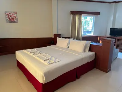 a bedroom with a large bed with white sheets at Sabai Sabai hotel in Kata Beach
