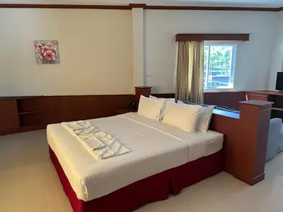 a bedroom with a large bed with a window at Sabai Sabai hotel in Kata Beach