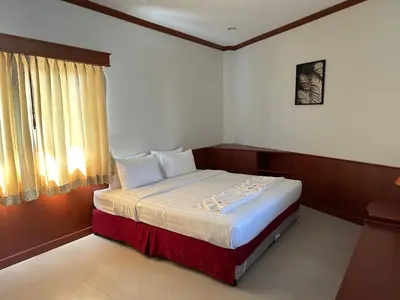 a bedroom with a large bed with a window at Sabai Sabai hotel in Kata Beach