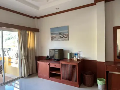 a living room with a tv and a table at Sabai Sabai hotel in Kata Beach