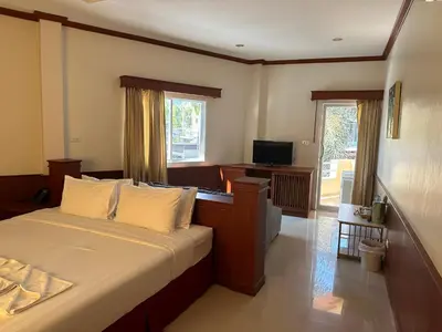 a bedroom with a bed with a desk and a television at Sabai Sabai hotel in Kata Beach