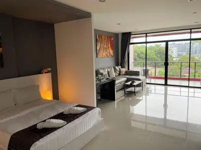 a bedroom with a bed and a living room at Nai Harn spacious studio great amenities in Rawai Beach