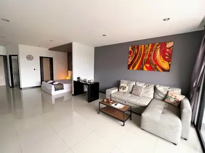 a living room with a couch and a table at Nai Harn spacious studio great amenities in Rawai Beach
