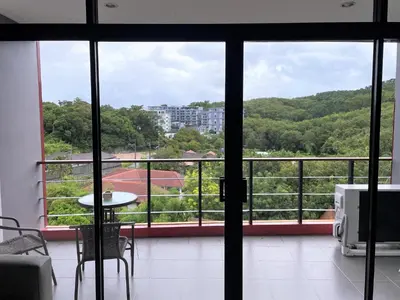a room with a view of a balcony with a table at Nai Harn spacious studio great amenities in Rawai Beach