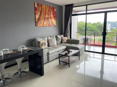 a living room with a couch and a table at Nai Harn spacious studio great amenities in Rawai Beach