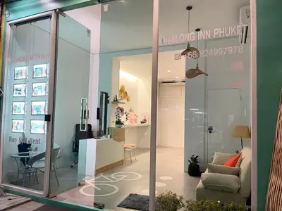 a room with a glass door with a living room at Chalong Inn Phuket in Ban Klang