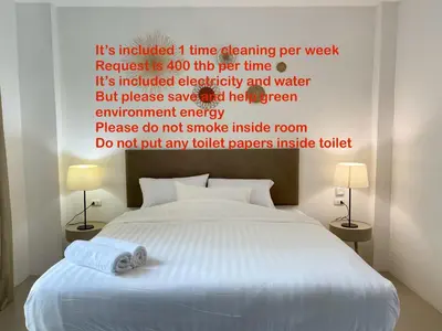 a bedroom with a bed with a poem on the wall at Chalong Inn Phuket in Ban Klang