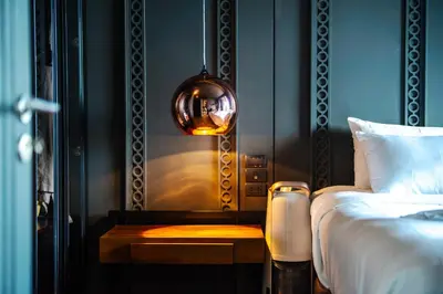a bedroom with a bed and a table with a lamp at Saturdays Residence By JJM in Ban Saiyuan (1)