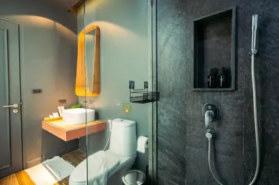 a bathroom with a shower and a toilet and a sink at Saturdays Residence By JJM in Ban Saiyuan (1)