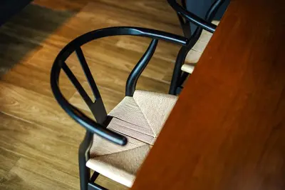 a black chair sitting next to a wooden table at Saturdays Residence By JJM in Ban Saiyuan (1)