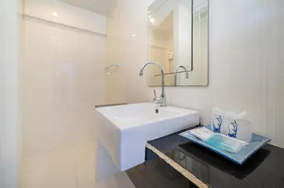a white bathroom with a sink and a mirror at Kata Sea Boutique in Kata Beach