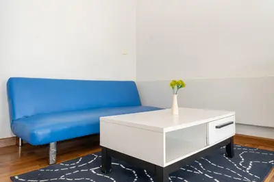 a living room with a blue couch and a white coffee table at Kata Sea Boutique in Kata Beach
