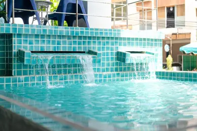 a swimming pool with a water fountain at Kata Sea Boutique in Kata Beach