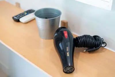 a hair dryer sitting on a desk next to a cup at Kata Sea Boutique in Kata Beach