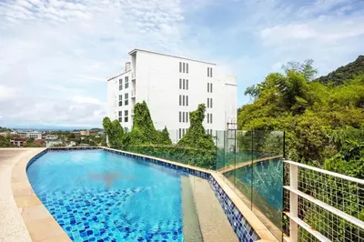 a swimming pool in front of a white building at Kata SeaView 2BR Apartment M12, just 5 min Drive from Kata Beach in Kata Beach
