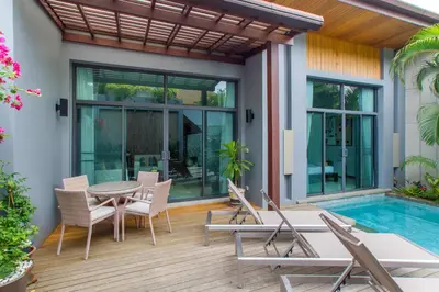 a patio with a table and chairs and a pool at Stylish 3BR Pool Villa Onyx H4, Gated Residence, Near Rawai & Naiharn Beach in Rawai Beach