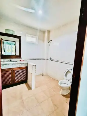 a bathroom with a toilet and a sink and a mirror at Siray House in Phuket Town