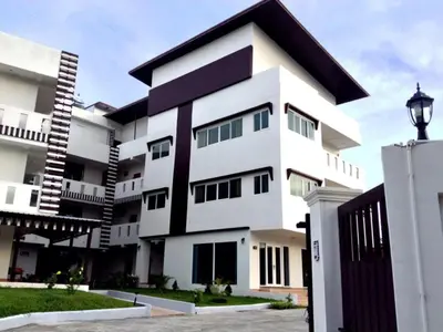 a white apartment building with a black roof at Siray House in Phuket Town