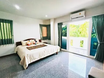 a bedroom with a bed and a large window at Siray House in Phuket Town