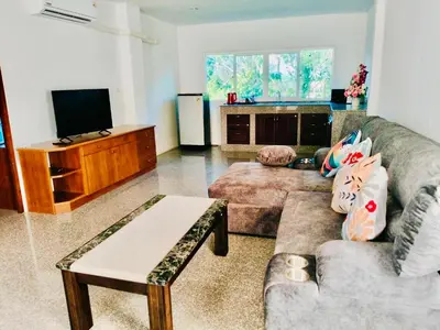 a living room with a couch and a tv at Siray House in Phuket Town