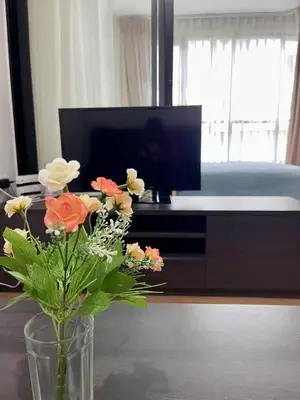 a vase with flowers on a table in a living room at cen 1 bed room 848 in Ban Rangeng