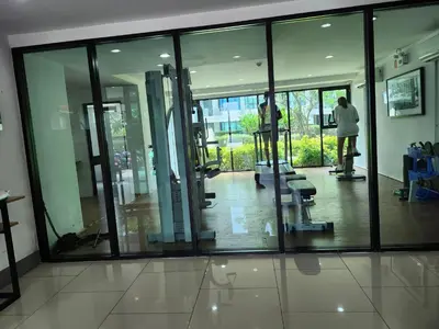 a room with glass windows and a person on a treadmill at cen 1 bed room 848 in Ban Rangeng