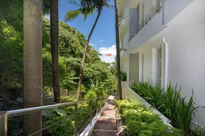 a walkway next to a building with palm trees at Kata Beach Luxury Condo - Spacious - Exquisitely Furnished - 6min walk to beach - 2025 Booking Traveller Award Winner in Kata Beach