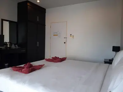 a white bed with red satinoms on top of it at Karon Sea Side in Karon Beach