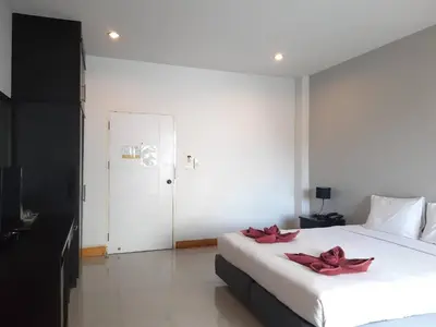 a bedroom with a large white bed with red flowers on it at Karon Sea Side in Karon Beach