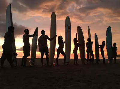 a group of people standing on the beach with their surfboards at Karon Sea Side in Karon Beach