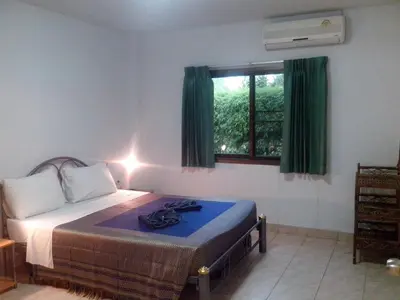 a bedroom with a bed and a window with green curtains at Sabai Residence in Ao Nang Beach