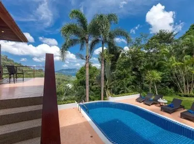 a house with a swimming pool and palm trees at Patonghill estate 6 bedroom sea view in Patong Beach