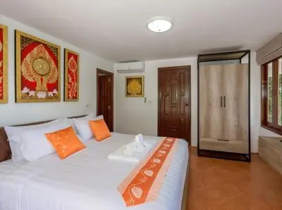a bedroom with a large white bed with orange pillows at Patonghill estate 6 bedroom sea view in Patong Beach