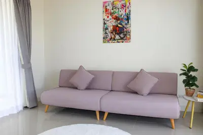 a couch with two pillows in a living room at Lovely Townhouse in Laguna Park in Thalang