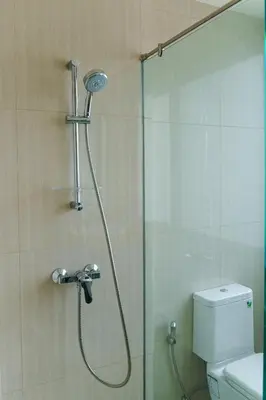 a shower in a bathroom with a toilet and a shower head at Lovely Townhouse in Laguna Park in Thalang