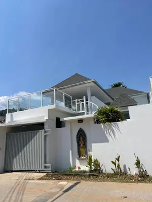 a white house with a balcony on top of it at John’s pool villa Rawai in Ban Saiyuan (1)