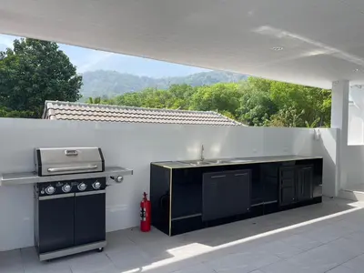 a outdoor kitchen with a grill and a stove at John’s pool villa Rawai in Ban Saiyuan (1)