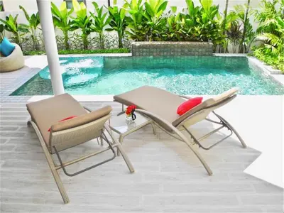 two chairs and a table next to a swimming pool at Beautiful Pool Villa near Rawai Beach in Rawai Beach
