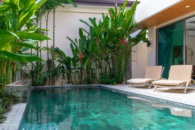 a pool in a backyard with chairs and plants at Beautiful Pool Villa near Rawai Beach in Rawai Beach