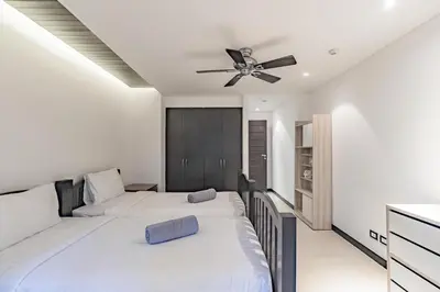 a bedroom with two beds and a ceiling fan at 3BR Casa Oasis - Beachfront Home in Laguna & Layan Chom Tawan and Maan Tawan Residences in Phuket Town